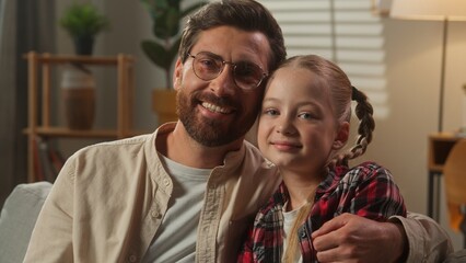 Caucasian family smiling portrait father with daughter smile looking at camera at home dad cuddling...