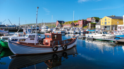Vibrant harbor life in the Faroe Islands with colorful boats and picturesque buildings