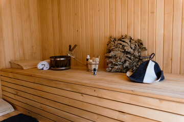 Rustic Wood Sauna Interior with Bucket, Birch Branches, Towels, Hat and Broom  Relaxing Spa Scene,...