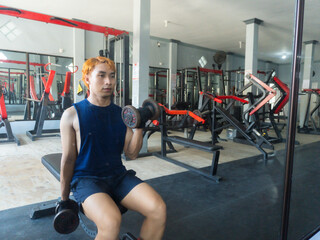 Asian men use gym equipment to do tricep, chest, arm exercises, focusing on building strength and...