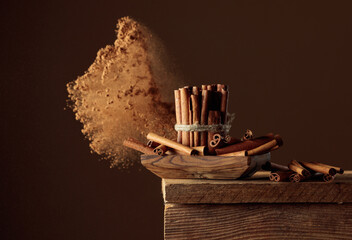 Cinnamon sticks and powder on a brown background.