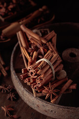 Cinnamon sticks, anise, and nutmeg on a wooden table.