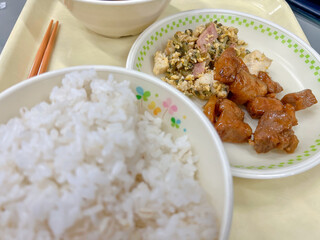 Japanese school lunch tray set featuring native foods of Okinawa, such as goya champuru (bitter melon stir-fry with tofu and egg) and rafute (pork braised belly).