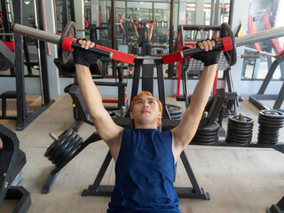 Asian men use gym equipment to do tricep, chest, arm exercises, focusing on building strength and...