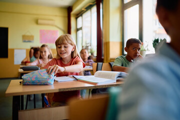 Happy girl and her classmates on class at elementary school.