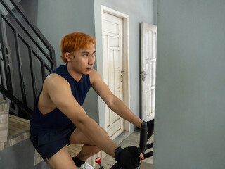 young sports indonesia asian man in blue cycling in fitness center. Cardio workout, leg workout,...