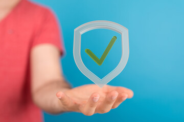 Hand holding a digital shield with a checkmark, symbolizing data security, safety, and privacy.