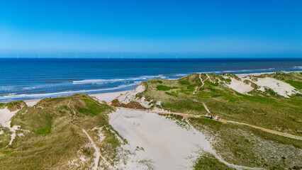 Breathtaking coastal landscape in Denmark with sandy dunes and clear blue ocean