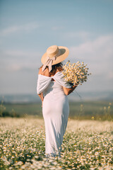 Daisies Woman Field: Lady in white dress holds flowers in daisy meadow during daytime for summer mood.
