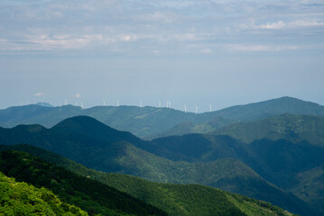 四国の山並みと遠くに並ぶ風力発電