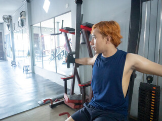 Asian men use gym equipment to do tricep, chest, arm exercises, focusing on building strength and...