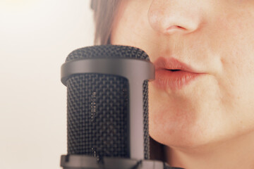 Close-up of young caucasian female singing into microphone