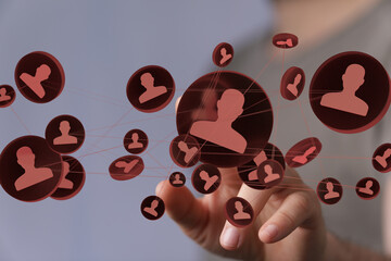 Hand interacting with digital network, showing connections between people. Social media, networking.