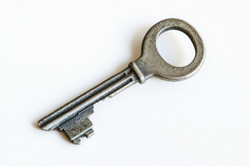 Isolated antique metal key with circular handle on a plain white background
