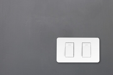 White light switch on dark gray wall with copy space