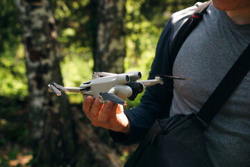 A man holds a drone in his hand. A man is about to launch a quadrocopter