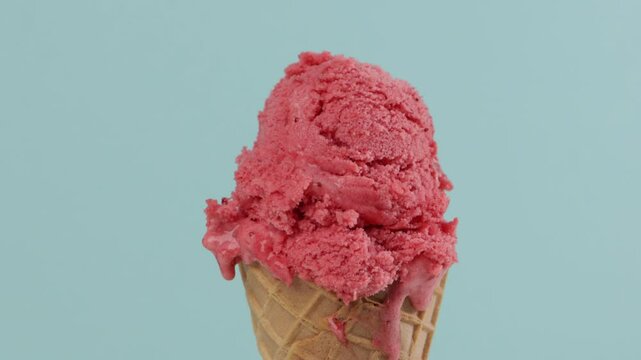 melting pink sorbet in waffer coner blue background zoom
