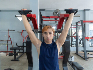 Asian men use gym equipment to do tricep, chest, arm exercises, focusing on building strength and...