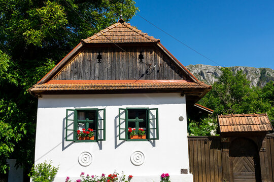 Traditional white hungarian house with green windows , flower decoration in Rimetea in romanian, Torocko in hungarian in Transylvania, Romania.