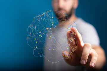 A man's hand interacts with a digital sphere, representing a global network or connection.