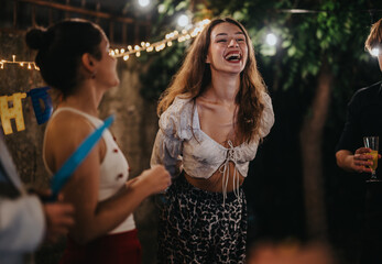 A group of friends enjoying a joyful birthday celebration outdoors in a warmly lit backyard. The atmosphere shows laughter, cheerfulness, and a sense of togetherness during an evening garden party.