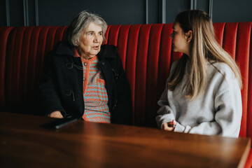 An intimate moment between an elderly woman and a young girl, engaging in a heartfelt conversation...