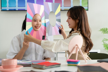 Stylist consulting client with color palettes in creative studio