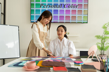 Stylist consulting client with color palettes in creative studio