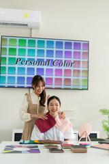 Stylist consulting client with color palettes in creative studio