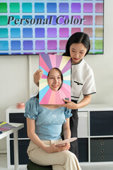 Stylist consulting client with color palettes in creative studio