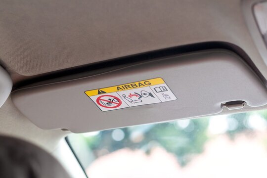 A sun visor in a car with airbag safety sticker label