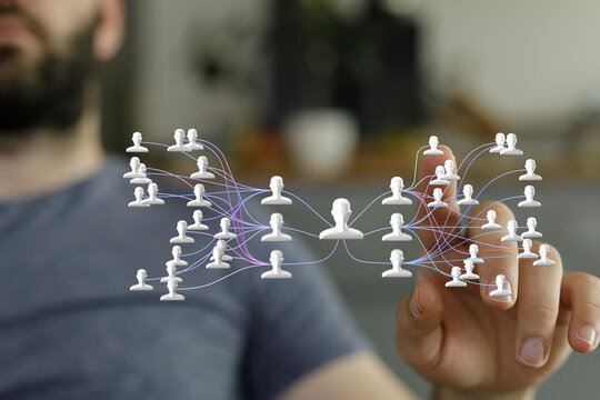 A man interacts with a digital network visualization, showing connections between people.