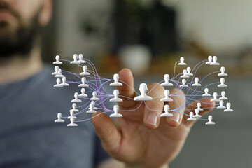 A hand interacts with a digital network, visualizing connections and relationships.