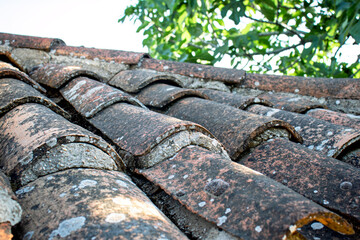 Old worn tiles. Roofing, waterproofing. Surface. Building material background. Red tiles that require maintenance. Top view, above.	