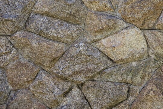 A stone wall with a rough texture