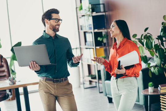 Professional colleagues engaging in a friendly discussion at a modern office space, collaborating on a joint business project