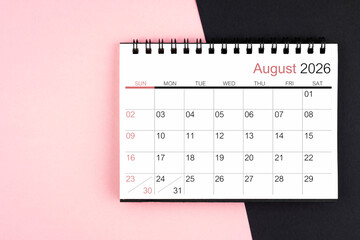 August 2026 desk calendar on pink and black color background, Flat lay.