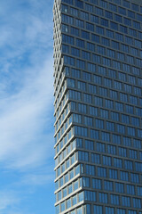 Fototapeta premium New York City Modern high-rise building with a unique geometric design and glass facade reflecting the sky. The architectural structure features a twisting pattern of windows and clean lines