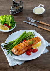 Grilled Salmon with Asparagus, Tomatoes and Lemon on White Plate