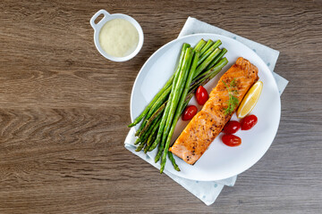 Grilled Salmon with Asparagus, Tomatoes and Lemon on White Plate