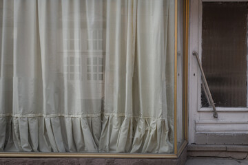 Soft sunlight filters through delicate curtains in a cozy street corner, inviting a sense of calm...