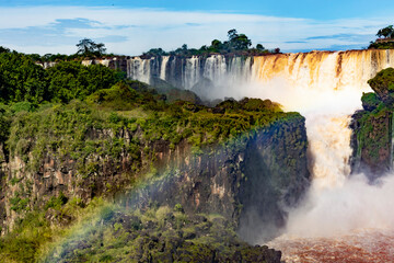 Breathtaking panoramic view of Iguazu Falls surrounded by lush forest. The powerful waterfalls...