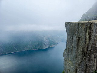 Majestic cliff overlooking the tranquil waters of Norways stunning fjord landscape