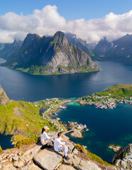 Stunning panoramic view of Lofoten Islands with hikers overlooking the fjord in Norway