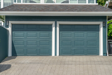 Garage door in luxury house with trees and nice landscape in Spring in Vancouver, Canada, North America. Day time on May 2025.