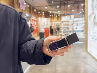 Man buying make up at cosmetics section in store. choosing cosmetics, perfumes, creams and...