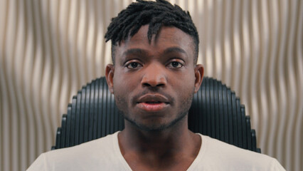 Close up portrait African American ethnic man male guy serious mood unsmiling confident emotion headset in futuristic studio futurism room looking at camera gaze face expression confidence indoors
