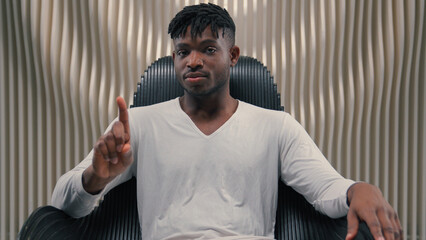 Serious confident African American ethnic man male guy gamer modern futuristic white room indoors cyberspace looking at camera technology vr shaking finger no gesture forbidden not never refuse deny