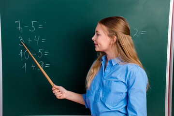 Young girl teaching basic math concepts in a classroom setting with enthusiasm