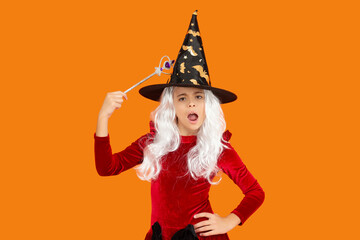 Halloween costume party. All Hallows witch girl. Girl in witch costume hold magic wand. Happy Halloween. Girl witch in Halloween costume isolated on orange. Trick or treat. Having fun